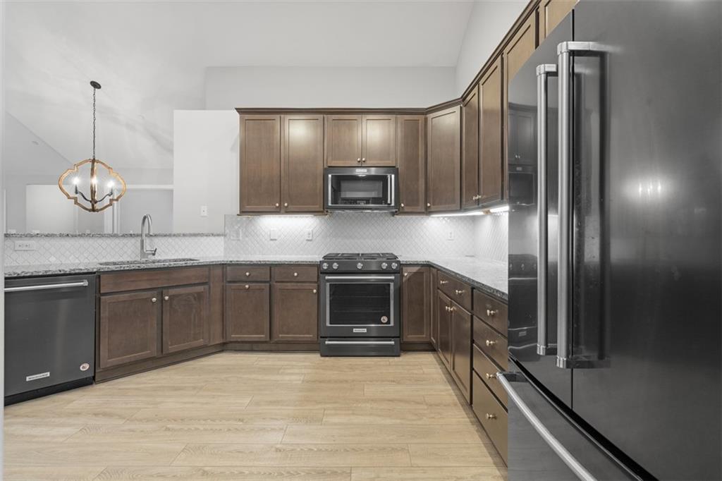 103 Spring Valley Drive Zelienople, PA 16063 - Photo 10 of 42 a kitchen with stainless steel appliances granite countertop a refrigerator a stove and a sink with wooden floor