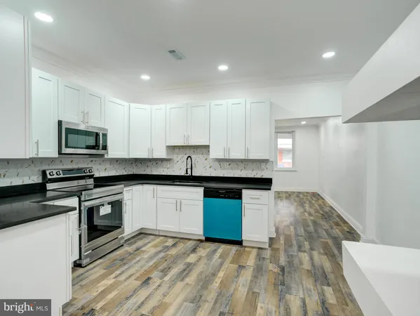 a kitchen with granite countertop white cabinets stainless steel appliances and a sink