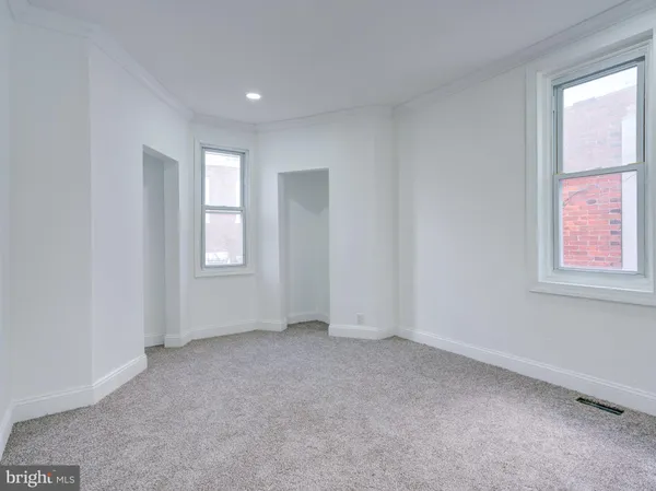 an empty room with windows and closet
