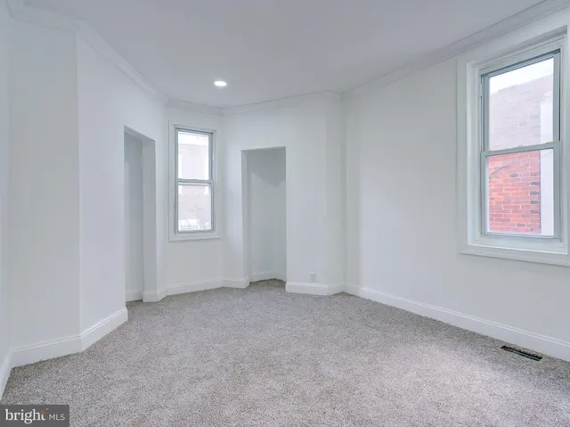 an empty room with windows and closet