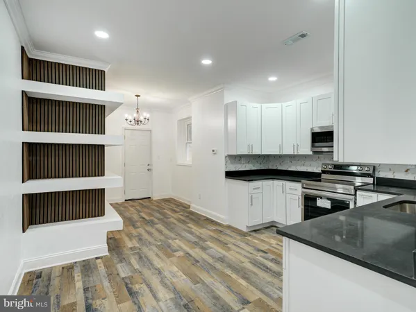 a kitchen with granite countertop a stove a sink and a microwave