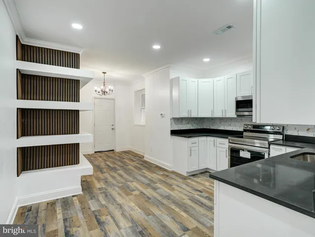 a kitchen with granite countertop a stove a sink and a microwave