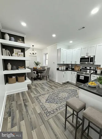 a kitchen with a refrigerator and a view of living room