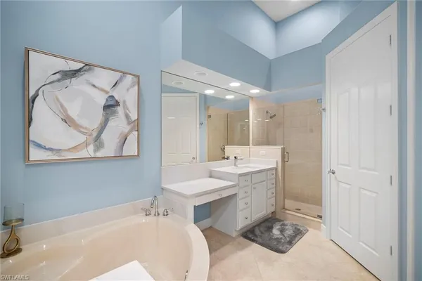 a bathroom with a tub sink and mirror