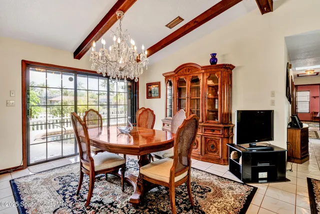 a view of a dining room with furniture and a chandelier