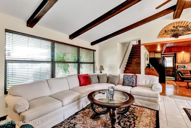 a living room with furniture a large window and a fireplace