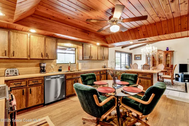 a outdoor kitchen with a sink and wooden cabinets