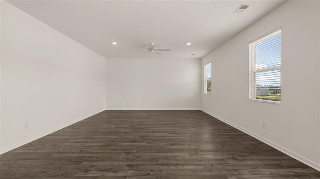 307 Friendship Oak Way Hampton, GA 30228 - Photo 14 of 35 an empty room with wooden floor and windows