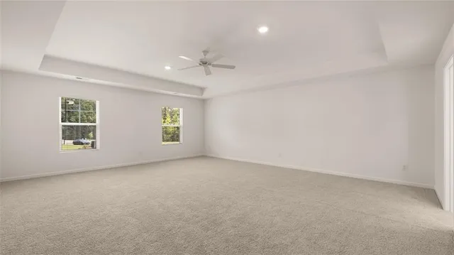 an empty room with a window and a ceiling fan