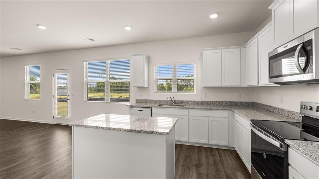 307 Friendship Oak Way Hampton, GA 30228 - Photo 6 of 35 a kitchen with stainless steel appliances granite countertop a sink stove and microwave
