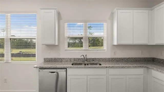 a bathroom with a granite countertop cabinets and a sink