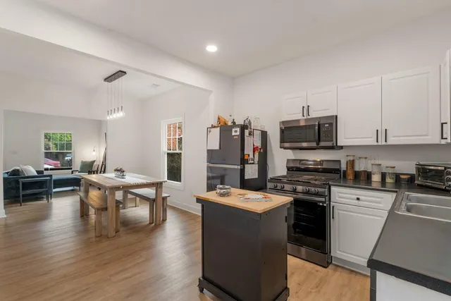 a large white kitchen with stainless steel appliances