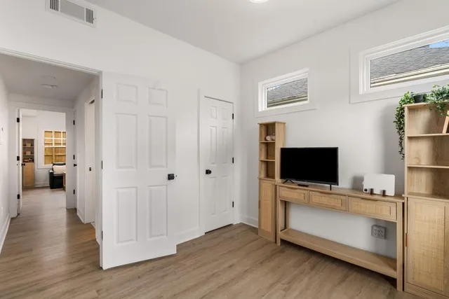 a view of a livingroom with wooden floor and flat screen tv