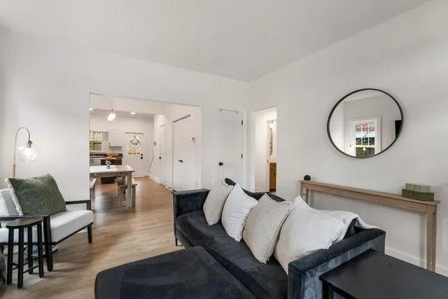 a living room with furniture a mirror and a large mirror