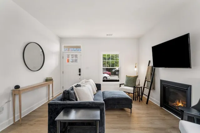 a living room with furniture a fireplace and a flat screen tv