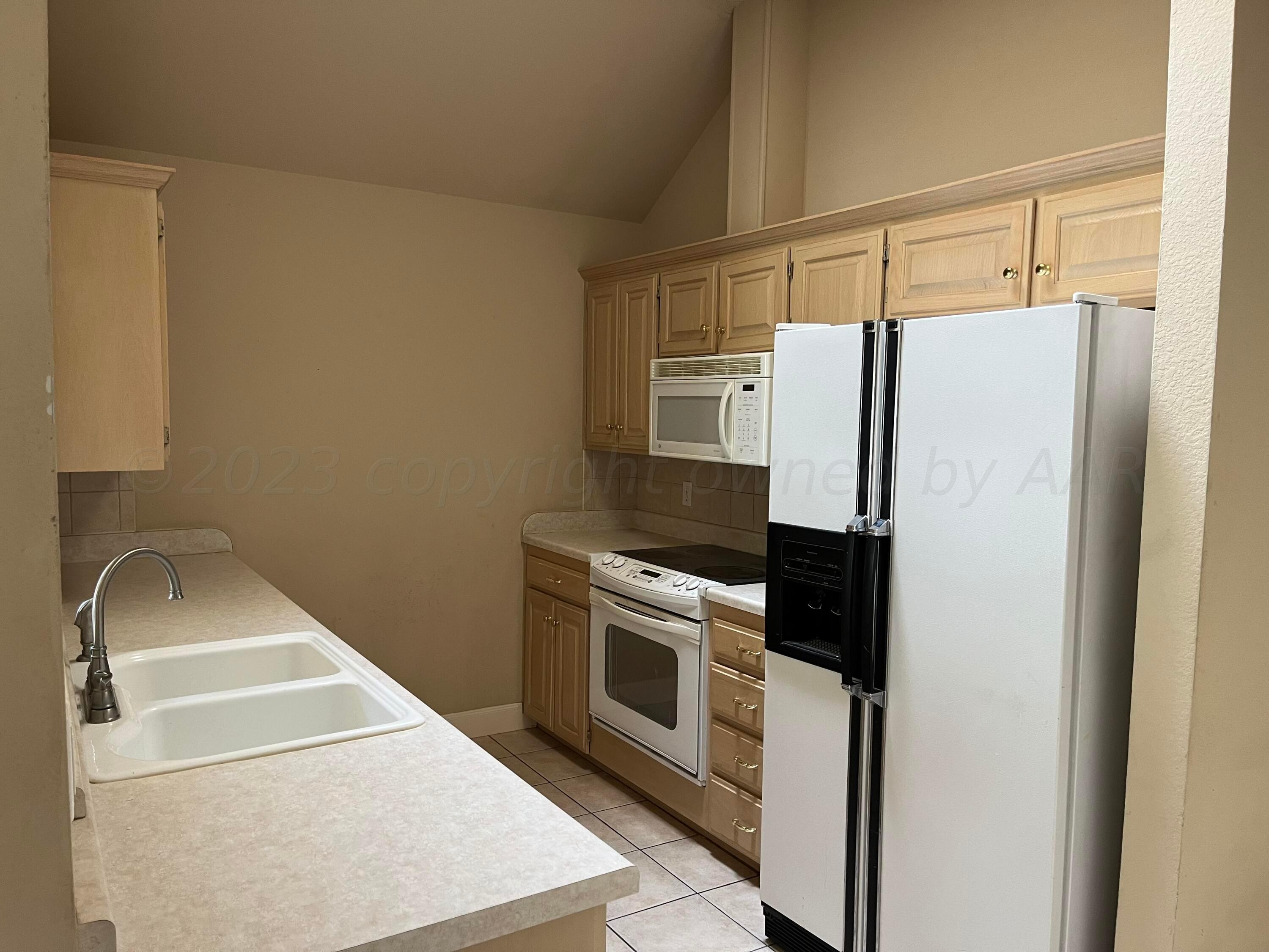 2 Windtree Amarillo, TX 79121 - Photo 4 of 15 a white refrigerator freezer and a stove sitting inside of a kitchen