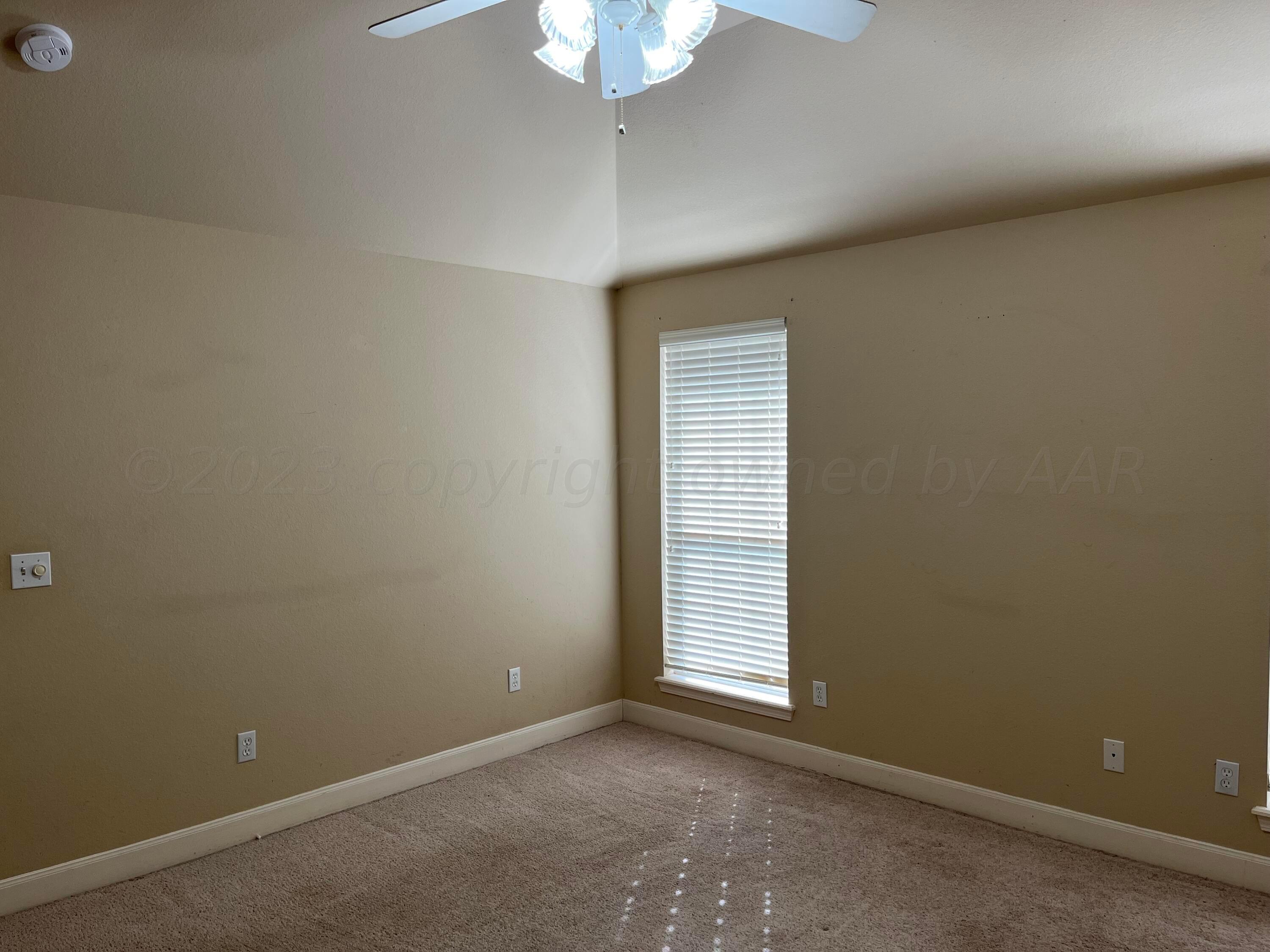 2 Windtree Amarillo, TX 79121 - Photo 7 of 15 an empty room with a chandelier fan and windows