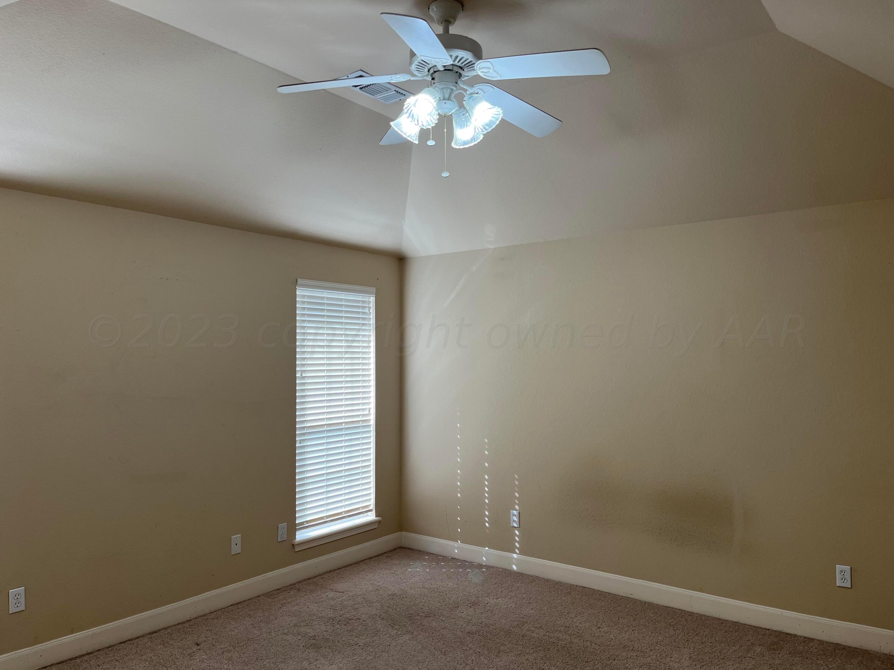 2 Windtree Amarillo, TX 79121 - Photo 8 of 15 an empty room with a chandelier fan and windows