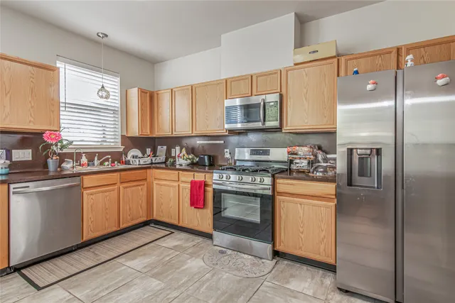 a kitchen with stainless steel appliances granite countertop a stove a sink and a refrigerator