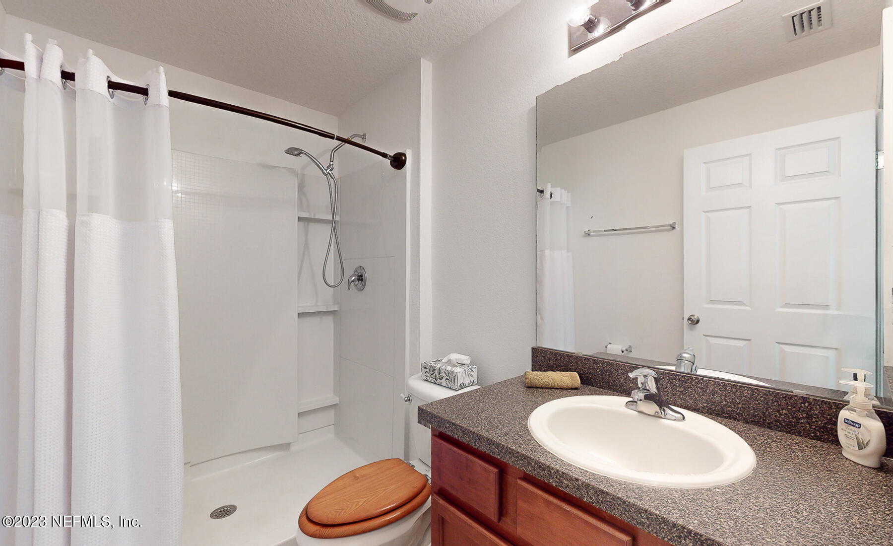303 Golden Lake Loop St. Augustine, FL 32084 - Photo 18 of 38 a bathroom with a granite countertop sink toilet a mirror and shower