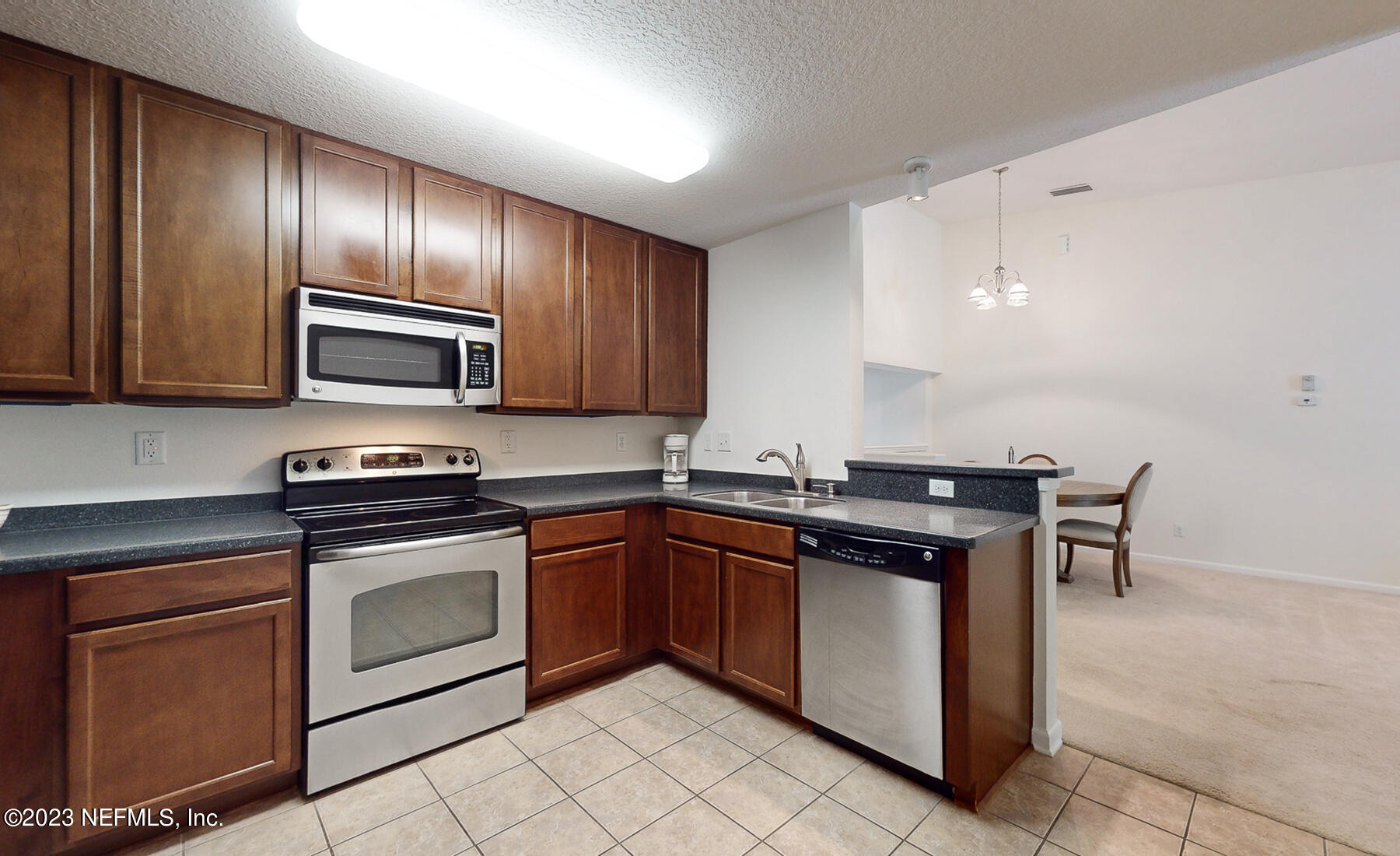 303 Golden Lake Loop St. Augustine, FL 32084 - Photo 2 of 38 a kitchen with stainless steel appliances granite countertop stove top oven microwave and cabinets