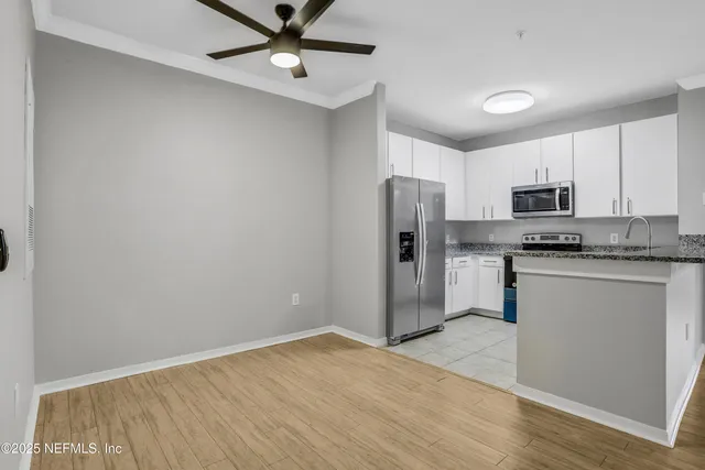 a kitchen with granite countertop a refrigerator and a stove top oven