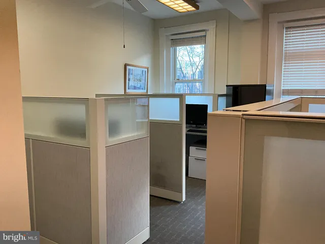 a view of a workspace with furniture and a window