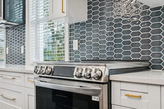 a open kitchen with stainless steel appliances granite countertop a sink dishwasher a stove and a dining table with wooden floor