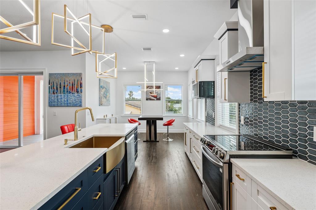 8605 Inwood Drive Hudson, FL 34667 - Photo 12 of 65 a open kitchen with stainless steel appliances granite countertop a sink dishwasher a stove and a dining table with wooden floor