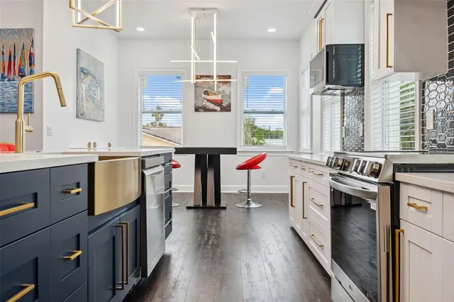 a kitchen that has a lot of cabinets a sink and a wooden floor