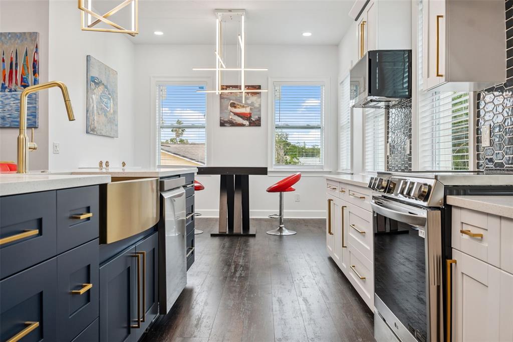 8605 Inwood Drive Hudson, FL 34667 - Photo 15 of 65 a kitchen with kitchen island granite countertop a stove a sink dishwasher and a refrigerator with wooden floor