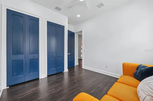 an empty room with wooden floor and closet area