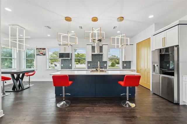 a kitchen with stainless steel appliances granite countertop a kitchen island a stove and a refrigerator