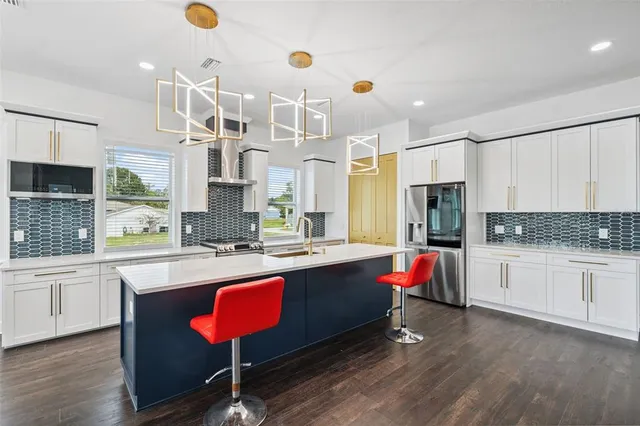 a kitchen with kitchen island granite countertop a sink and refrigerator