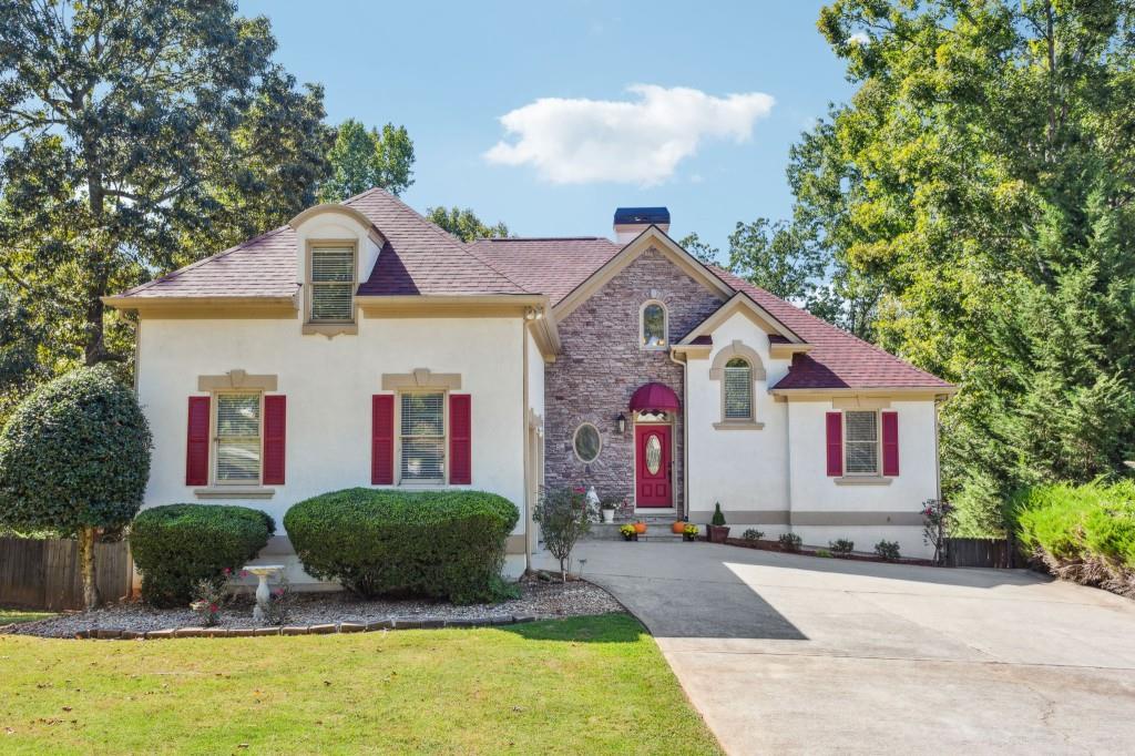 a front view of house with yard and trees around