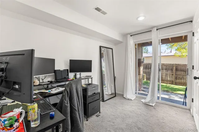 a view of a livingroom with workspace and a window