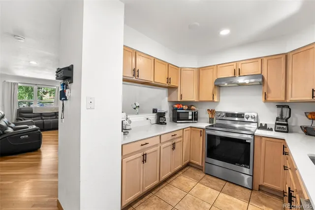 a kitchen with cabinets stainless steel appliances and wooden floor