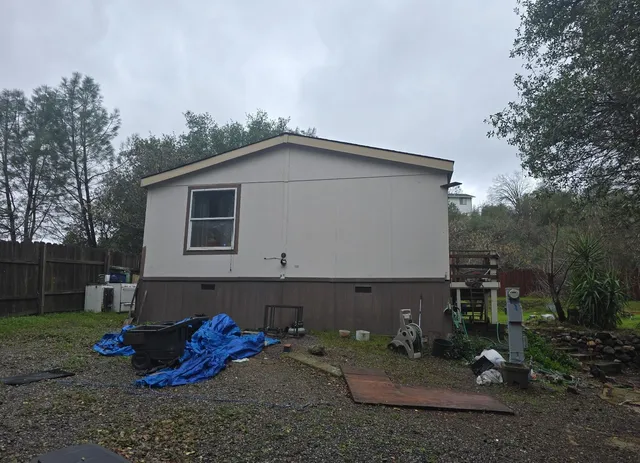 a view of a small house with yard and furniture