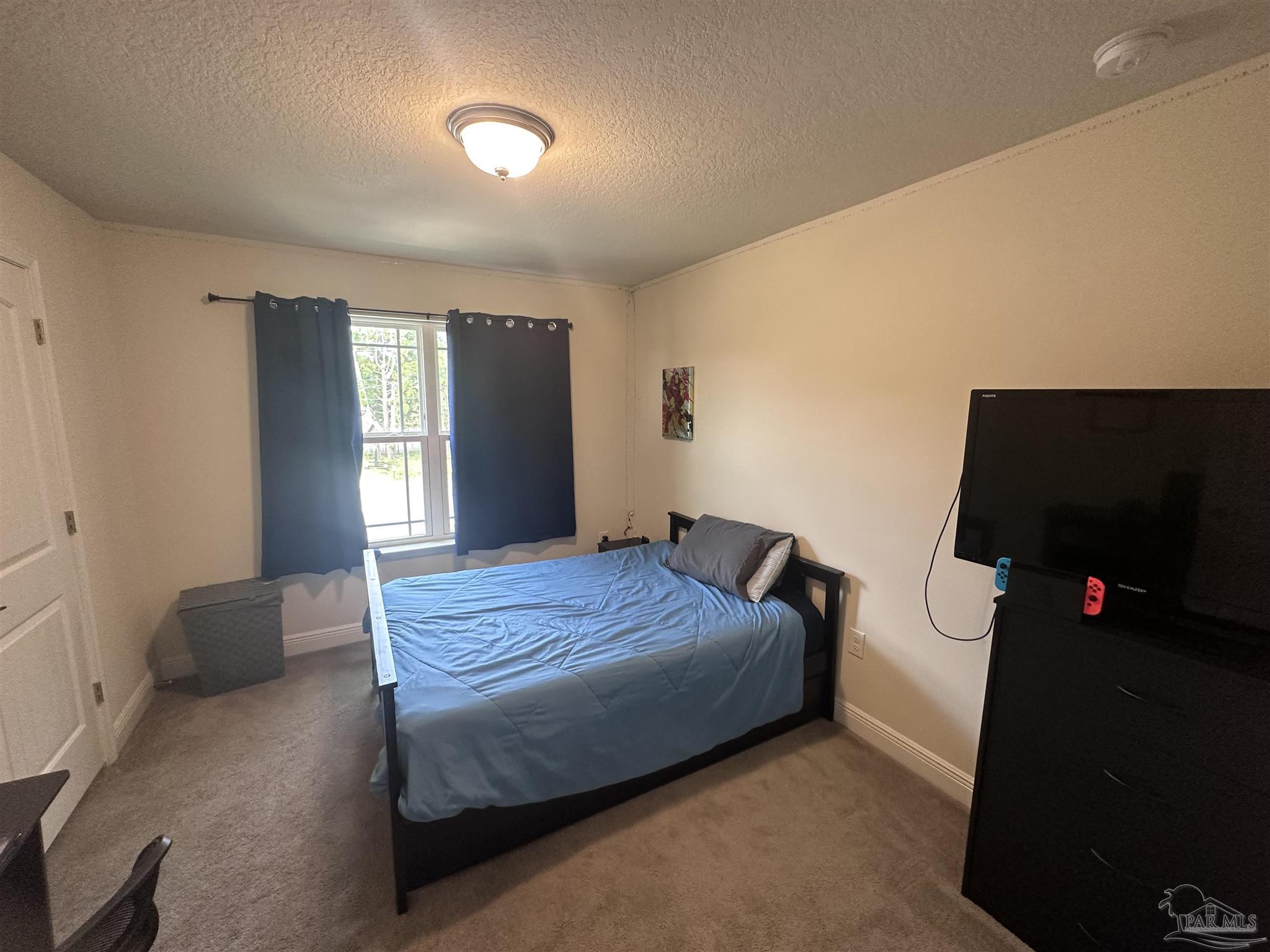 5217 Saufley Field Road Pensacola, FL 32526 - Photo 18 of 26 a bedroom with a bed and a flat screen tv