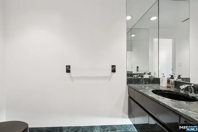 a bedroom with a bed table chair and a flat tv screen on a table