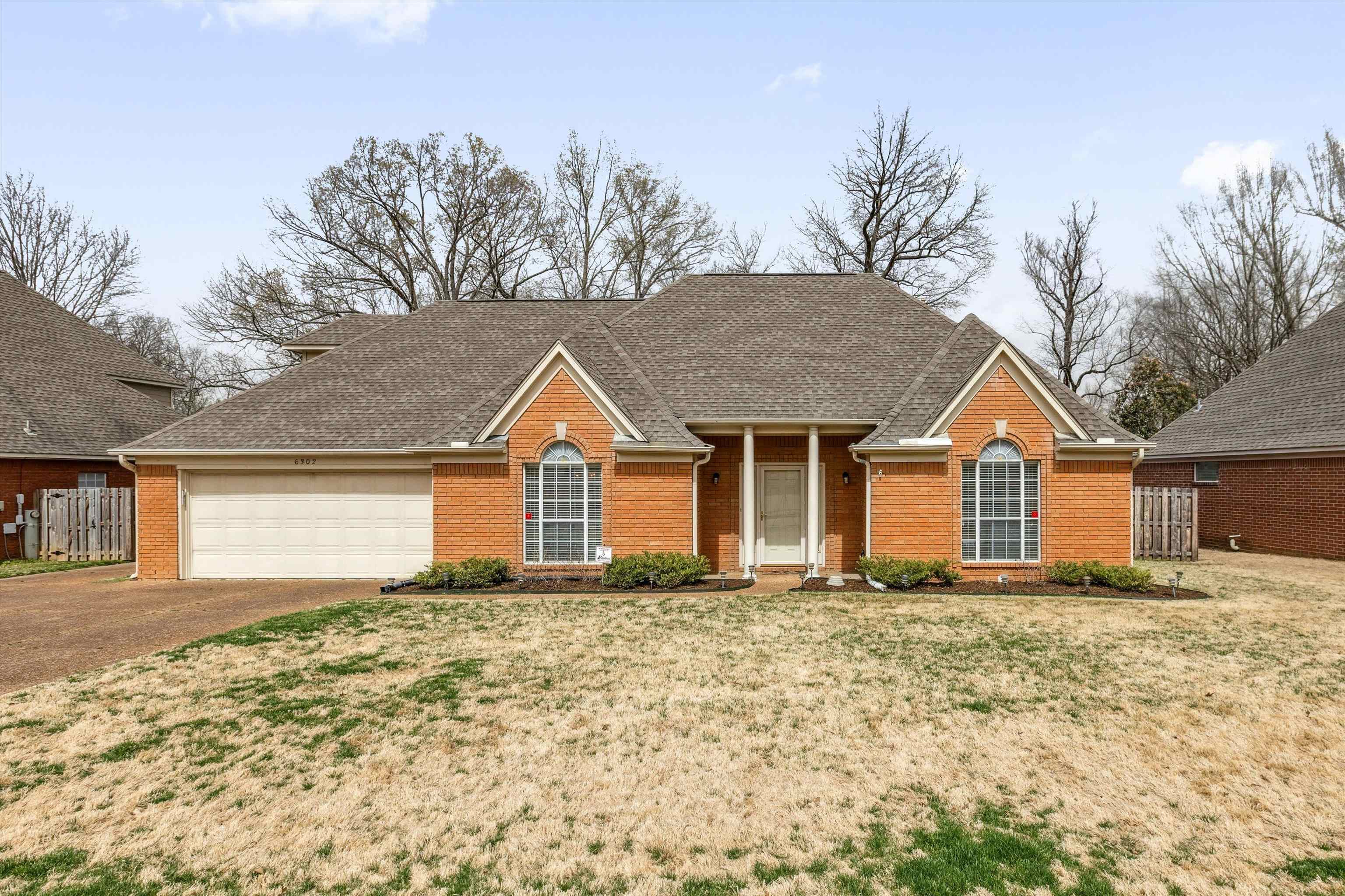 6302 Daybreak Drive Bartlett, TN 38135 - Photo 1 of 22 Single story home with brick siding, a front lawn, fence, concrete driveway, and a garage
