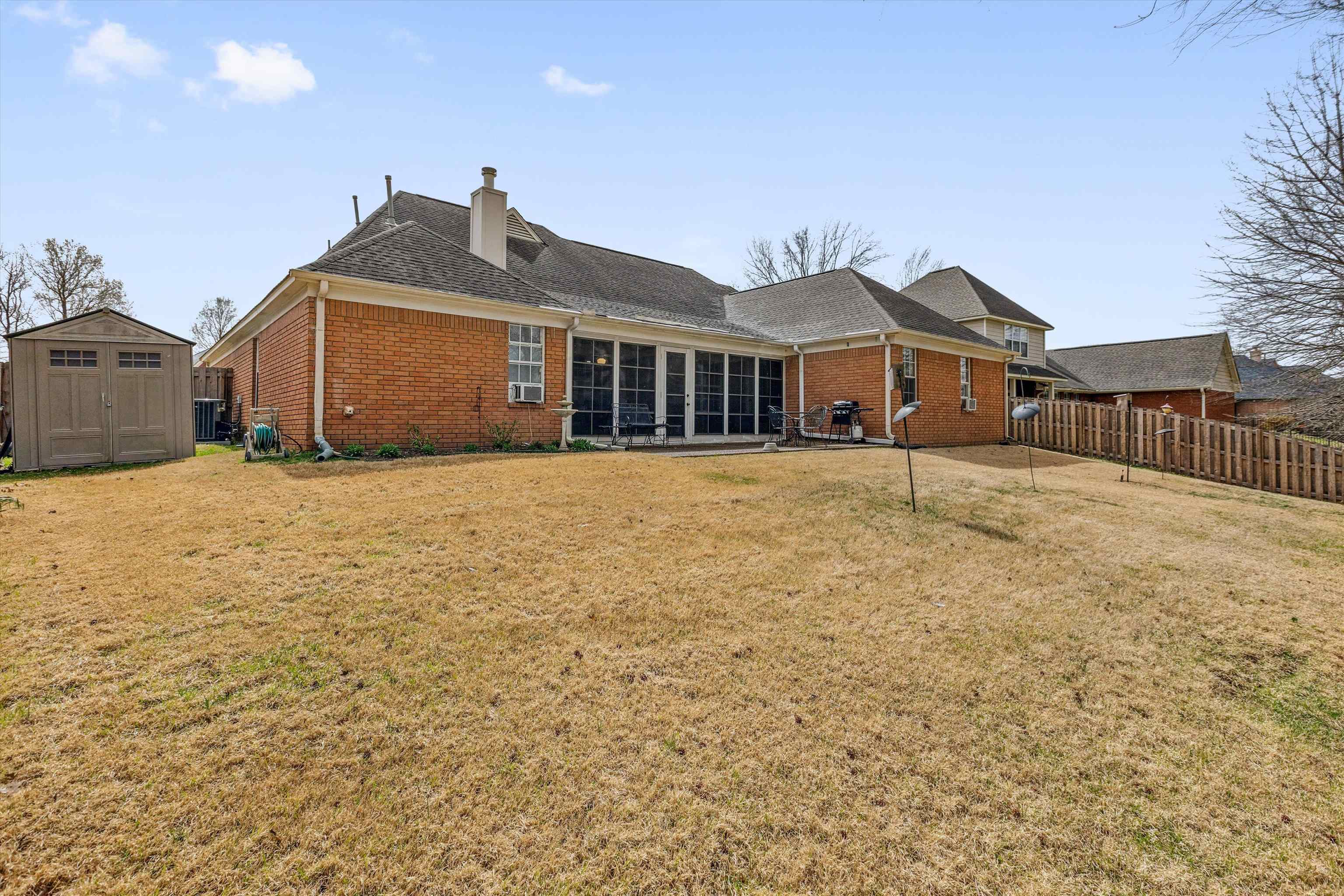 6302 Daybreak Drive Bartlett, TN 38135 - Photo 22 of 22 Rear view of house featuring brick siding, a shed, a yard, and an outdoor structure
