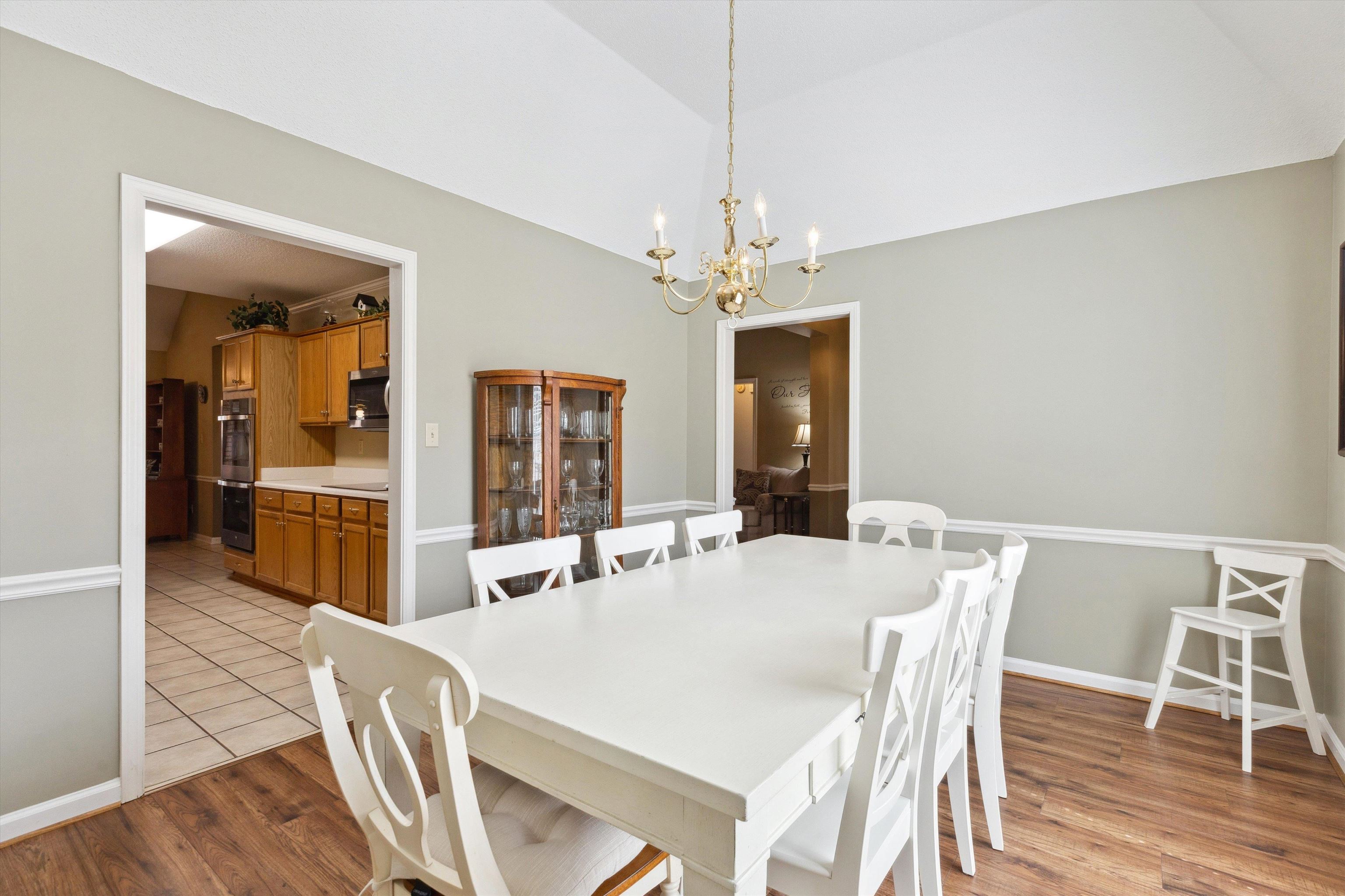 6302 Daybreak Drive Bartlett, TN 38135 - Photo 5 of 22 Dining room with an inviting chandelier, wood finished floors, baseboards, and vaulted ceiling
