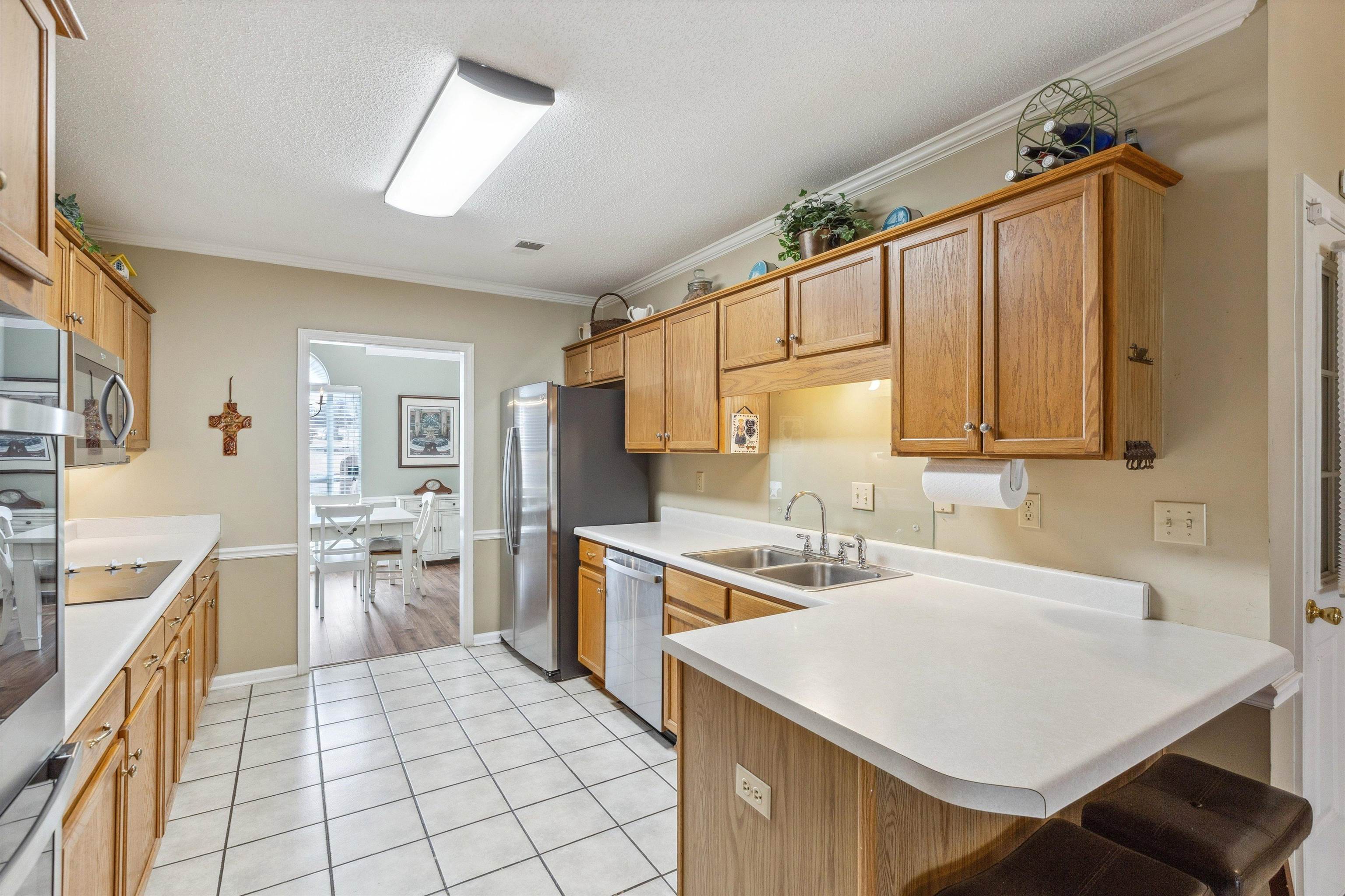 6302 Daybreak Drive Bartlett, TN 38135 - Photo 8 of 22 Kitchen featuring a peninsula, crown molding, stainless steel appliances, and a sink