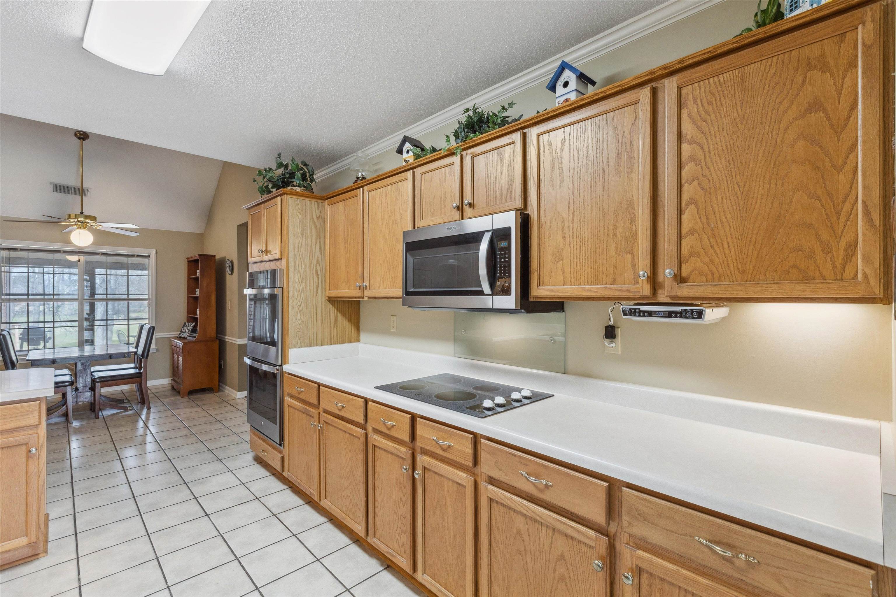 6302 Daybreak Drive Bartlett, TN 38135 - Photo 9 of 22 Kitchen with light tile patterned flooring, ceiling fan, light countertops, vaulted ceiling, and appliances with stainless steel finishes