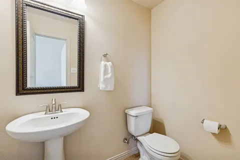 a bathroom with a toilet a sink and mirror