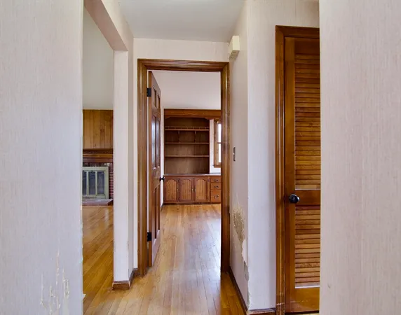 a view of a hallway with wooden floor and a living room