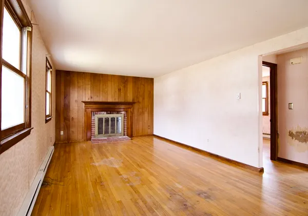 wooden floor in an empty room with a fireplace