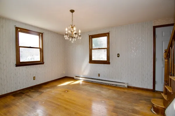 a view of empty room with window and chandelier
