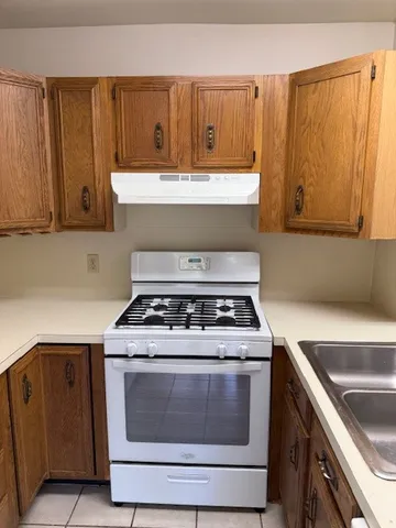 a white stove top oven sitting inside of a kitchen